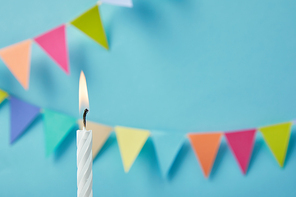 Candle on blue background with bunting