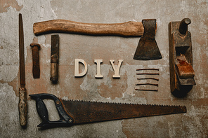 Flat lay with set of carpentry tools and diy sign on old surface