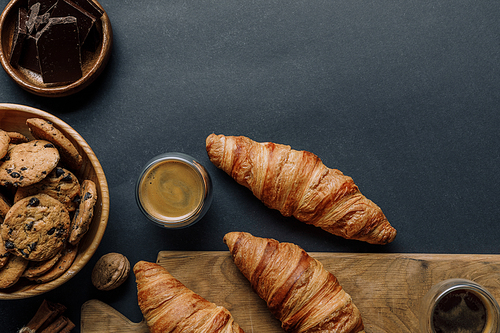 flat lay with walnut| coffee| croissants| chocolate and cookies on black table