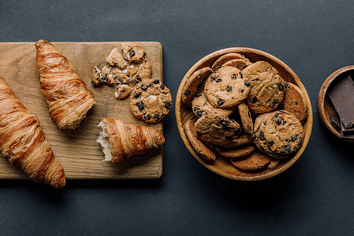 flat lay with arranged croissants| chocolate and cookies on black table