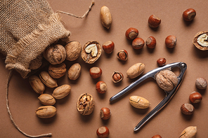 flat lay with nuts| nutcracker and sack on brown backdrop