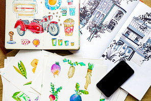 top view of watercolor drawings and smartphone