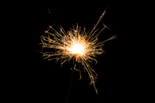 close-up view of burning and glowing christmas sparkler on black background