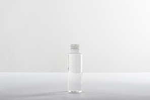 Cosmetic bottle with transparent liquid on white background with copy space