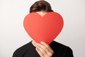 man with obscure face holding empty paper cut heart card isolated on grey