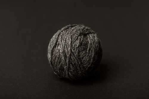 close up view of grey knitting ball on dark backdrop
