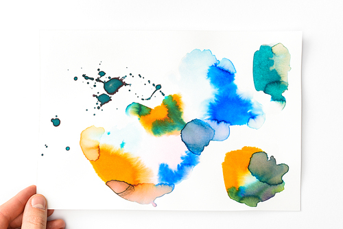 Man holding paper with abstract watercolor blue| golden and yellow spills on white background