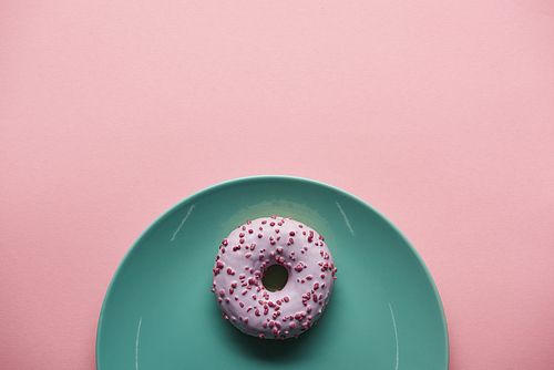 top view of glazed donut on blue plate isolated on pink