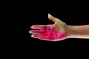 cropped view of adult woman with pink holi powder isolated on black