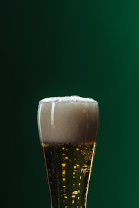 beer glass with foam and copy space isolated on green| st patrick day concept