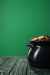 golden coins in pot isolated on green with copy space| st patrick day concept