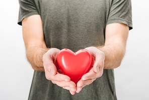 Cropped view of man in grey t-shirt holding toy heart