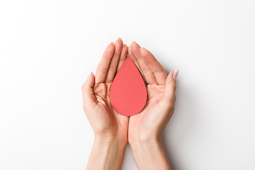 Partial view of woman holding paper drop on grey background