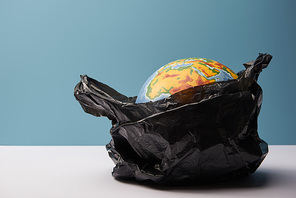 globe in black polyethylene bag on white table and blue background