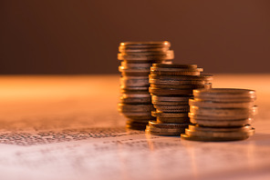 selective focus of coins stacks on text document and blurred background