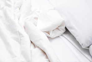 Close up of bed with white sheets and blanket