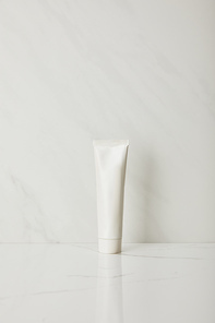 toothpaste in tube on white marble background
