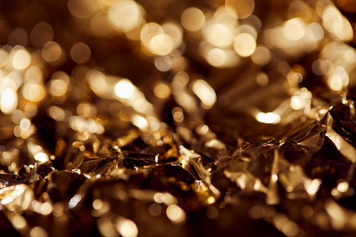 selrctive focus of foil with golden sparkling lights in shadows
