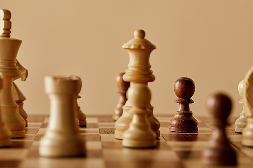 selective focus of chess pieces on chess board and beige background