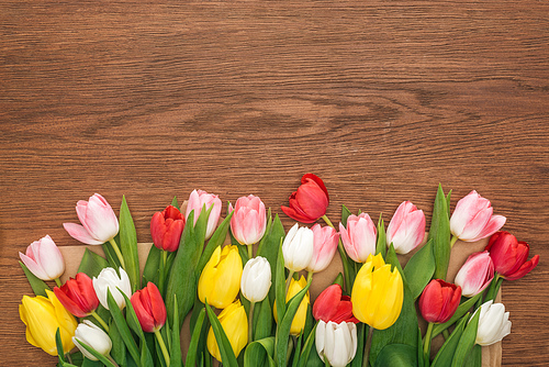 top view of colorful tulips on wooden background