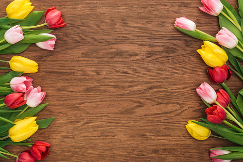 top view of colorful tulips on wooden background with copy space