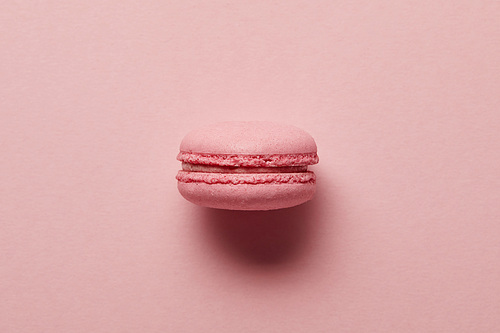 Pink french macaroon in center on pink background
