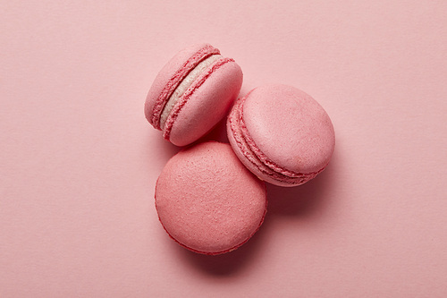 Tasty sweet pink french macaroons on pink background