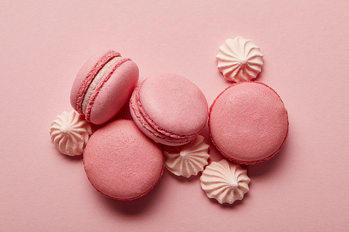 Pink macaroons with pink meringues on pink background