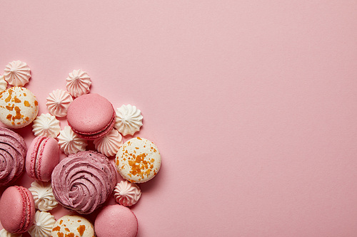 Delicious sweet pink and white macaroons with meringues on pink background