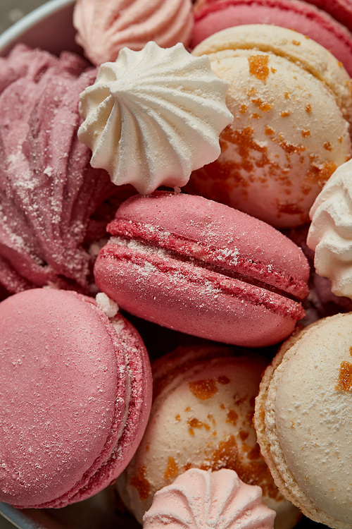 Delicious pink french macaroons with fluffy zephyr and small pink meringues with sugar pieces