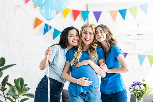 smiling multicultural friends with balloons and pregnant woman  at baby-party