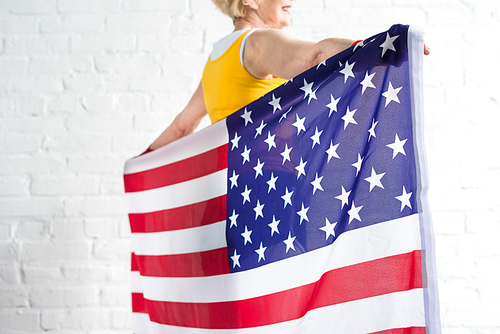cropped shot of senior sportswoman holding american flag