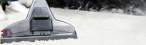 close-up view of hot steam cleaning of white carpet with professional vacuum cleaner