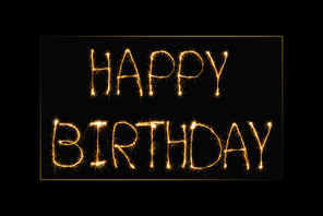 close up view of happy birthday light lettering on black backdrop
