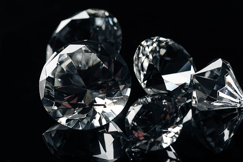 close up of collection of pure shiny diamonds isolated on black