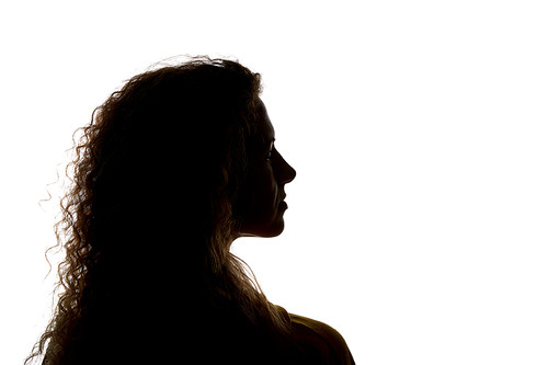 Silhouette of curly woman looking away isolated on white
