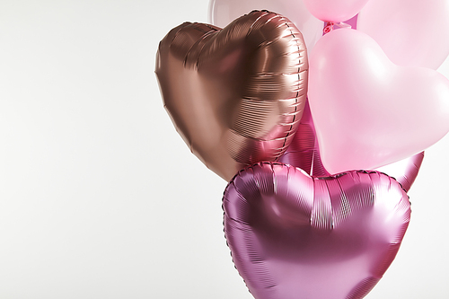 bundle of heart-shaped pink and golden balloons isolated on white with copy space