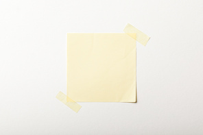 yellow blank paper with sticky tape on white background