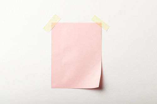 pink blank paper with sticky tape on white background