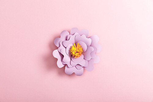 top view of lilac paper flower on pink background