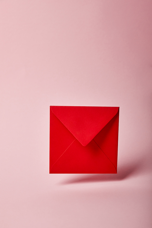 red and colorful envelope on pink background with copy space