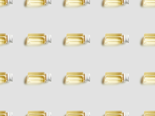 Top view of bottles with essential oil on grey background