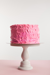 pink sweet birthday cake on cake stand isolated on grey