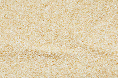 top view of golden and textured sandy surface on beach in summertime