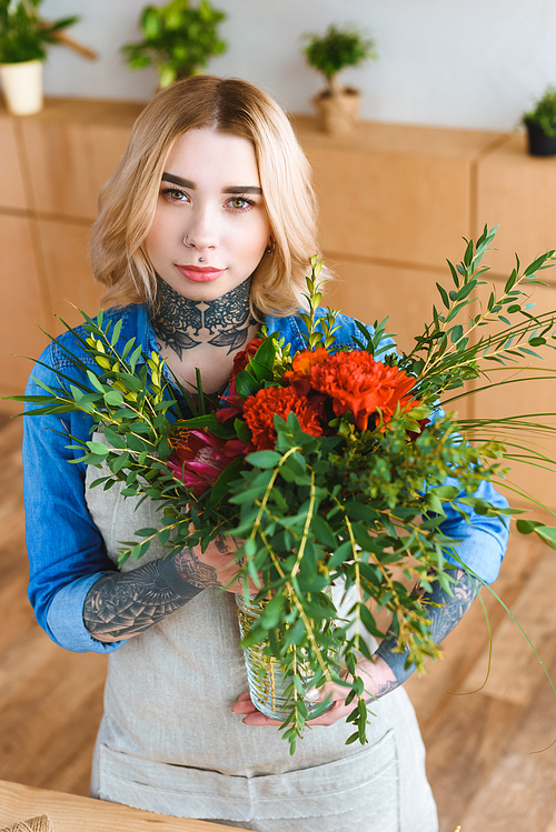 attractive young female florist holding flower bouquet and 