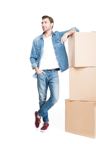 happy young man moving with cardboard boxes, isolated on white