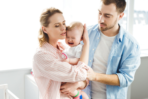 Parents trying to calm down crying infant daughter