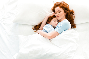 beautiful mother and daughter hugging and sleeping together in bed