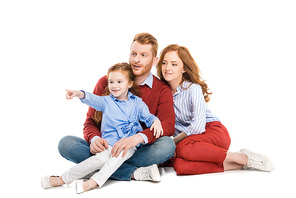 beautiful redhead family with one child sitting together and looking away isolated on white