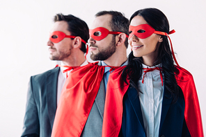 super businesspeople in masks and capes looking away in line in office